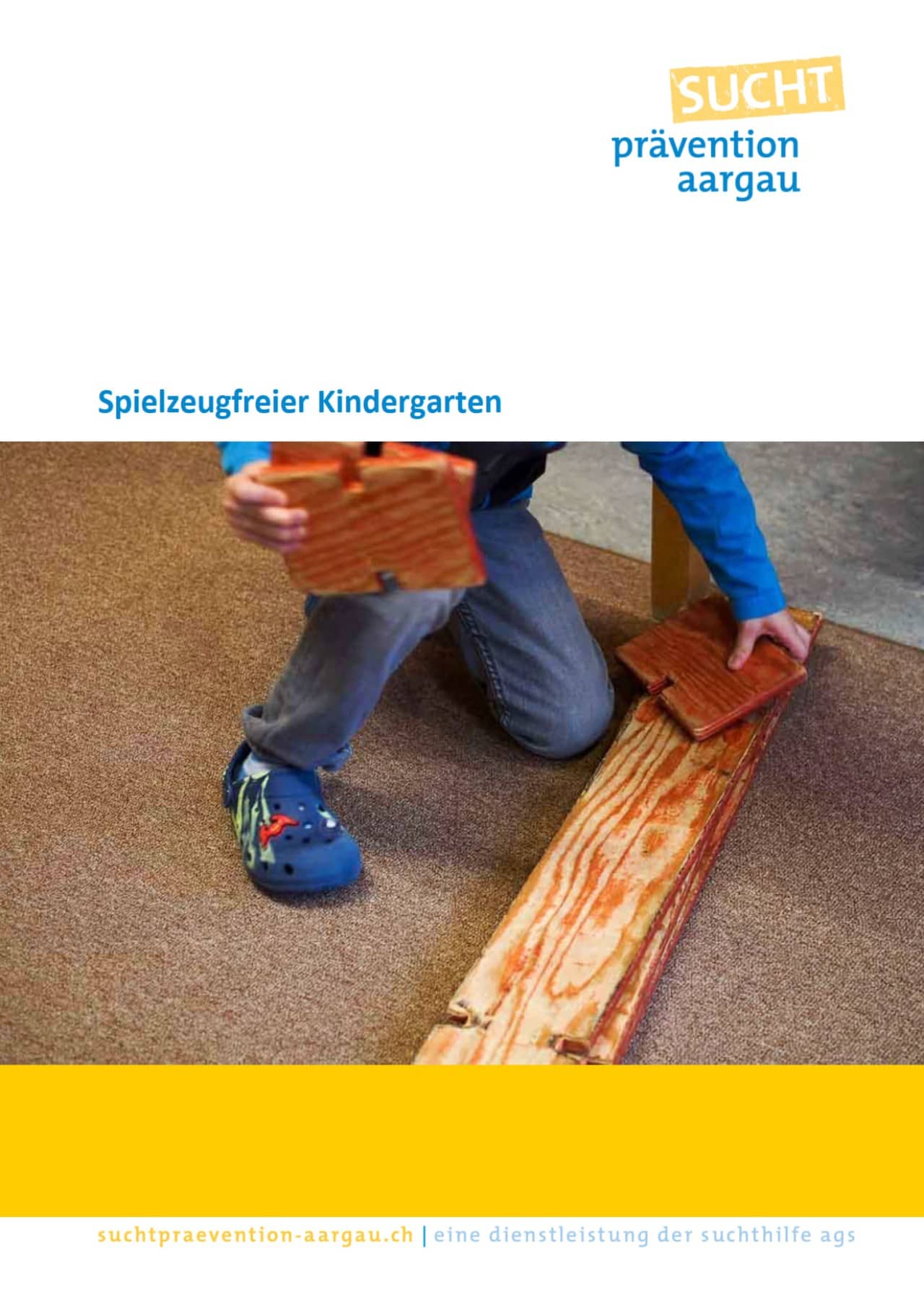 Titelseite einer Broschüre zum spielzeugfreien Kindergarten. Auf dem Bild sieht man ein ein Kind, das mit Holz spielt. 
