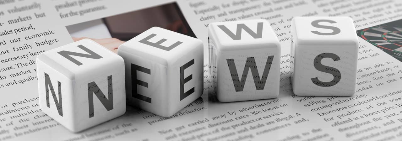 Vier Würfel mit den Buchstaben N, E, W und S auf einer Zeitung