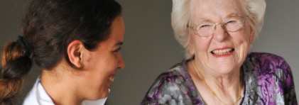 Eine lachende Frau mit einer Pflegerin