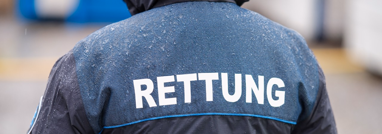 Person von hinten in Jacke, auf der "Rettung" steht.