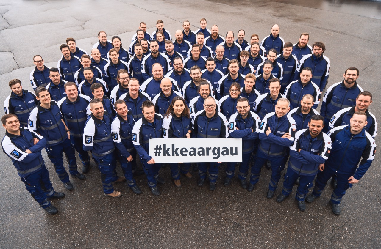 Zivilschützer bereiten eine Kernbohrung vor. Im Hintergrund sieht man ein Haus des Übungsdorfes.