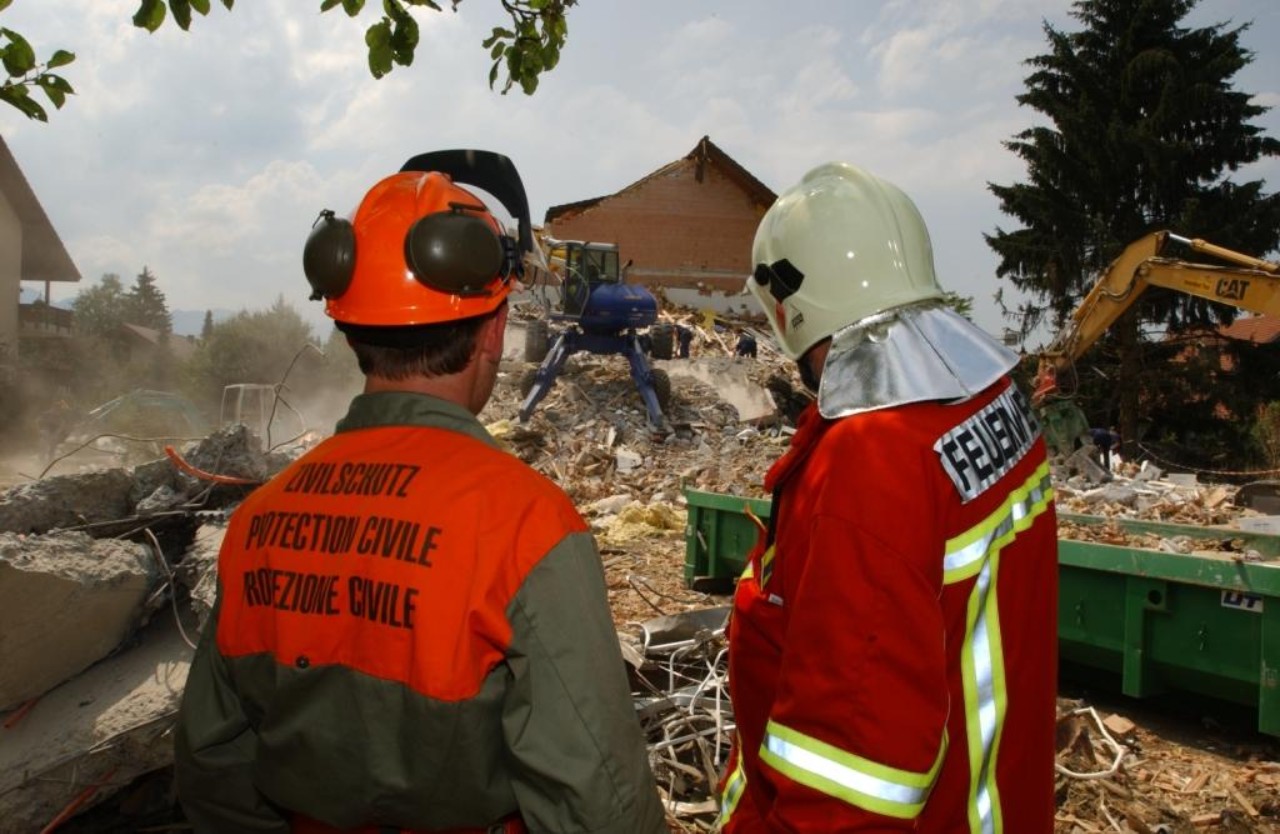 Zivilschutz und Feuerwehr auf einem Trümmerfeld