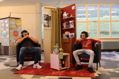 Zwei Männer sitzend mit Kopfhörern