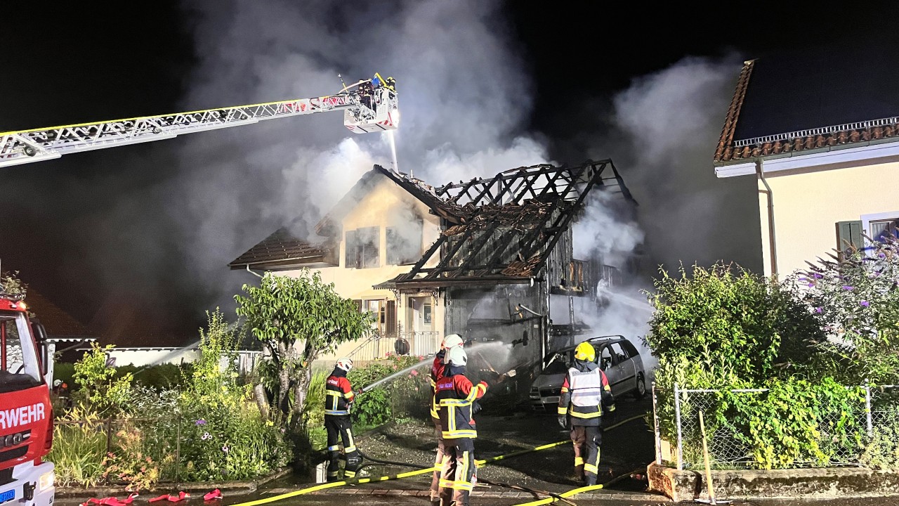 Ein Einfamilienhaus steht in Brand, die Feuerwehr löscht. Eine Autodrehleiter ist auch im Einsatz.