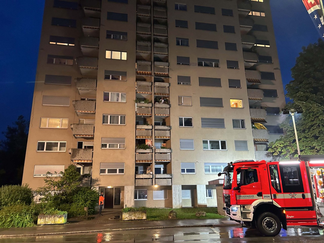 Feuerwehrauto vor Mehrfamilienhaus.