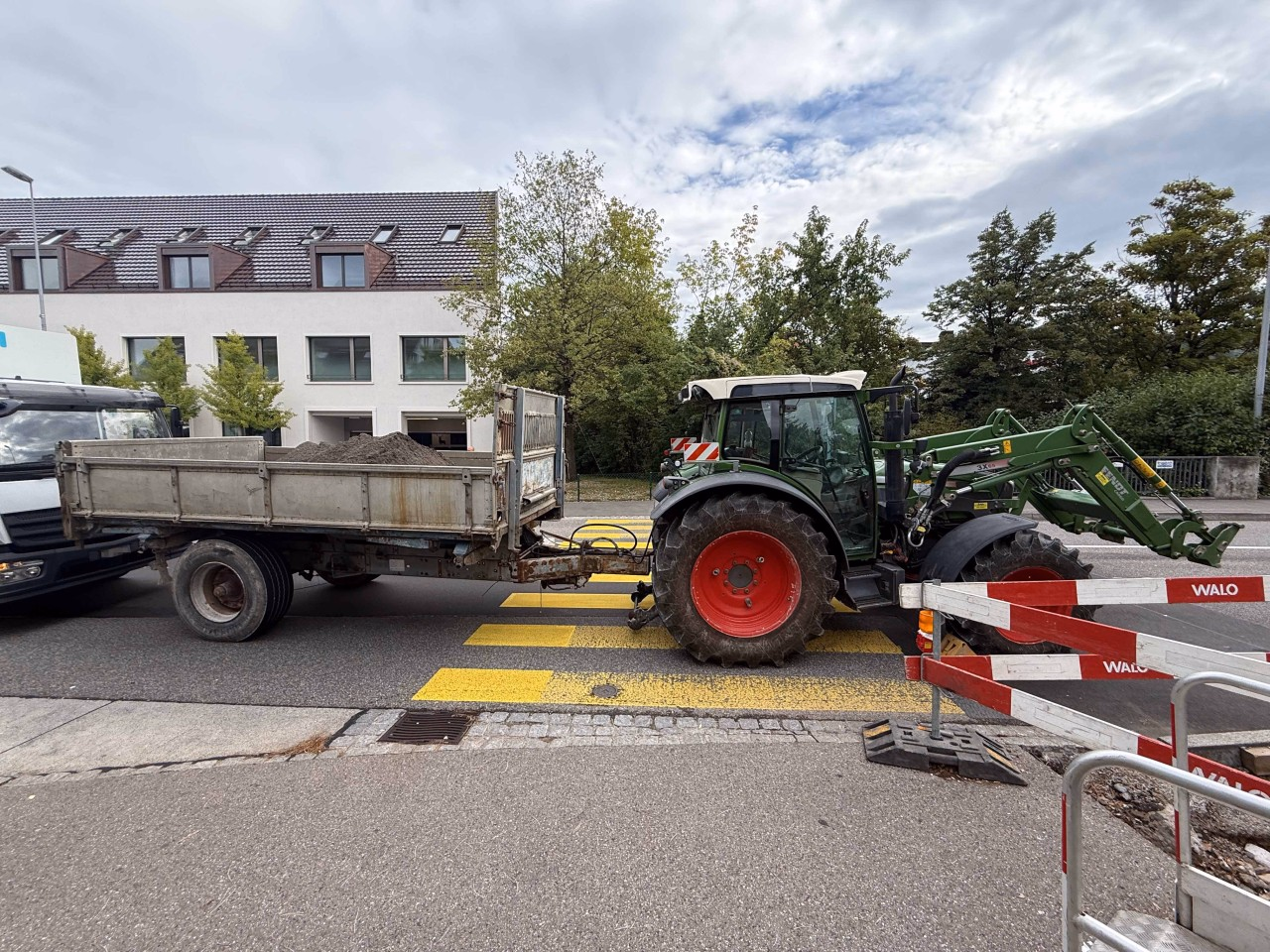 Traktor mit Anhänger auf Fussgängerstreifen. Anhänger mit dahinterstehendem Lastwagen kollidiert.