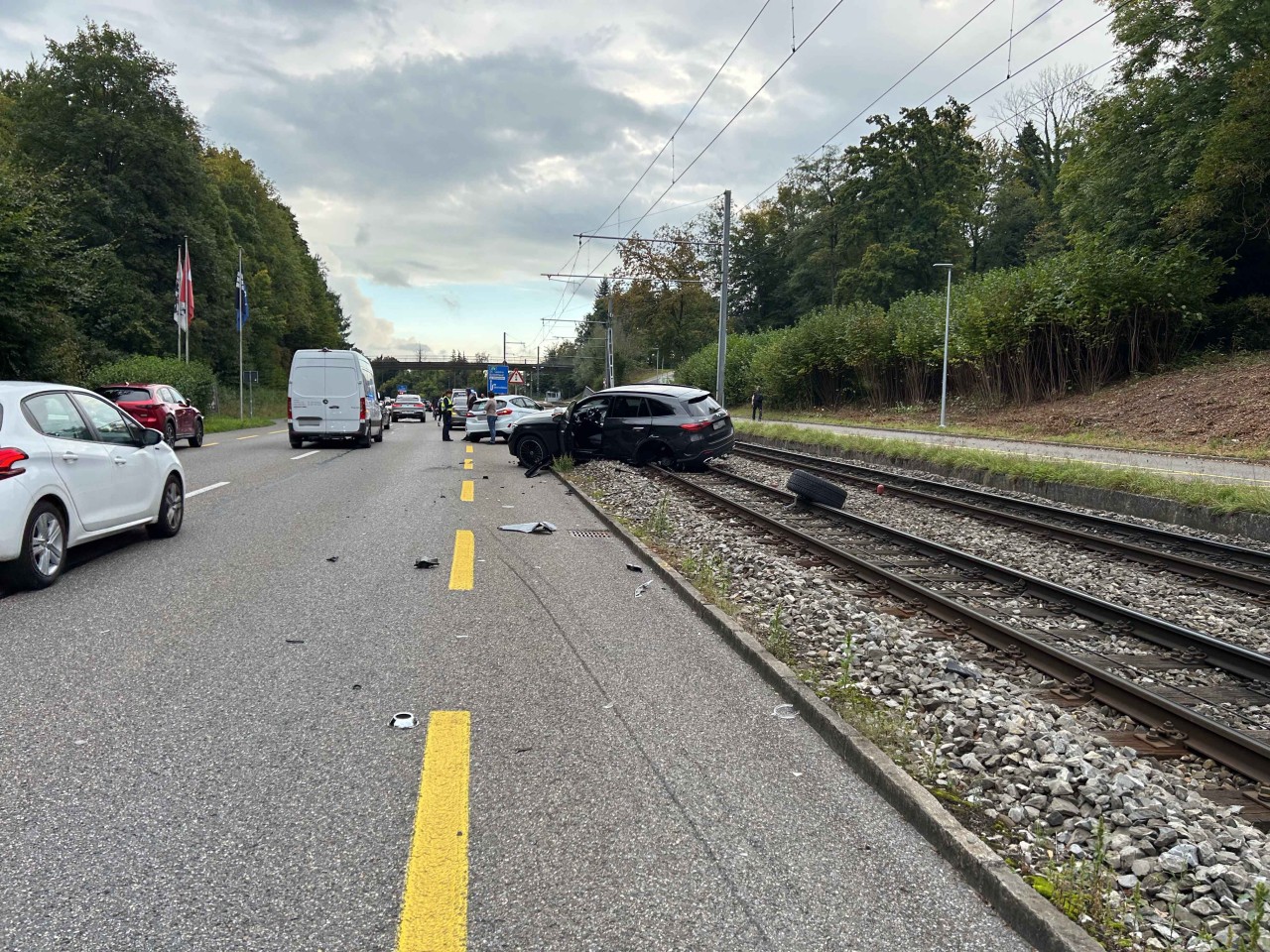 Schwarzer, beschädigter Mercedes auf den Geleise stehend.