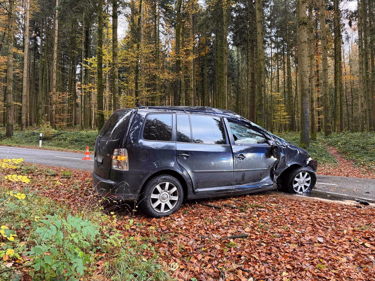 Stark beschädigtes schwarzes Fahrzeug.