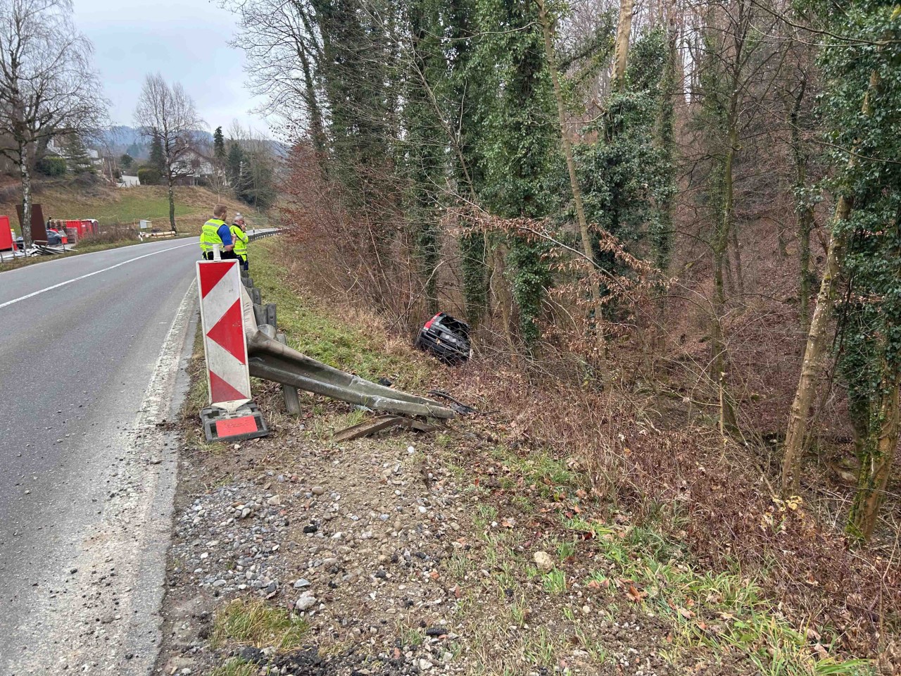Schwarzer Volvo, welcher neben der Fahrbahn in einem Abhang steht.