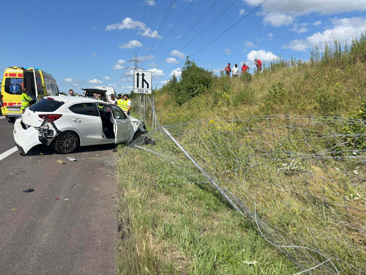 Demoliertes Auto auf dem Pannenstreifen.