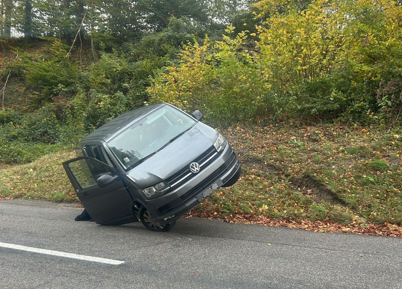 Unfallwagen in Schräglage an Böschung.