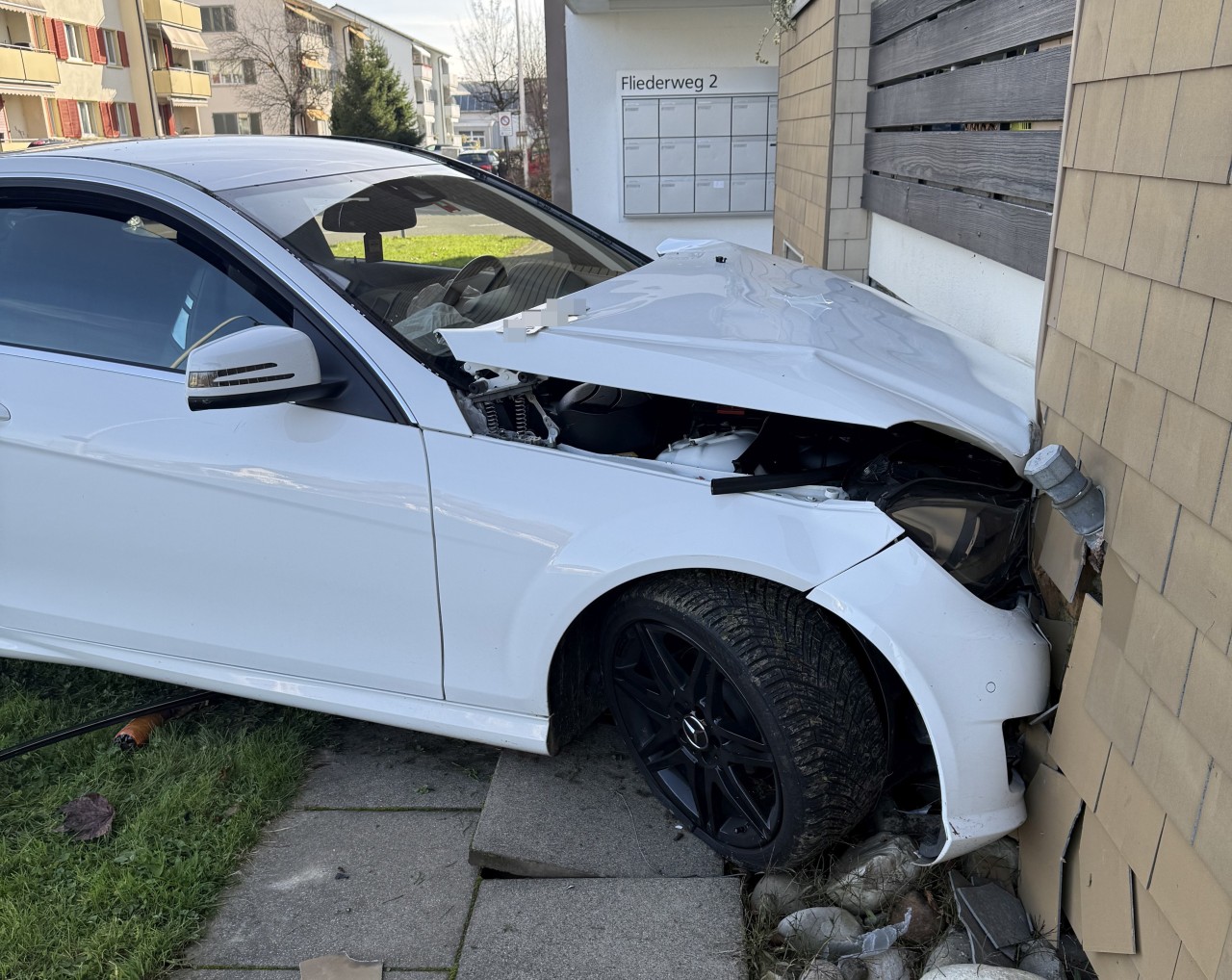 Demolierter Unfallwagen in Hauswand.