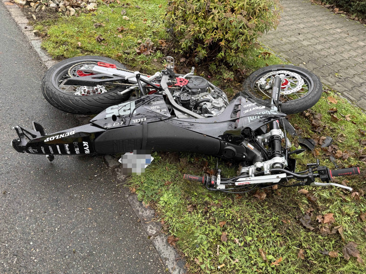 Beschädigtes Motorrad am Boden liegend.