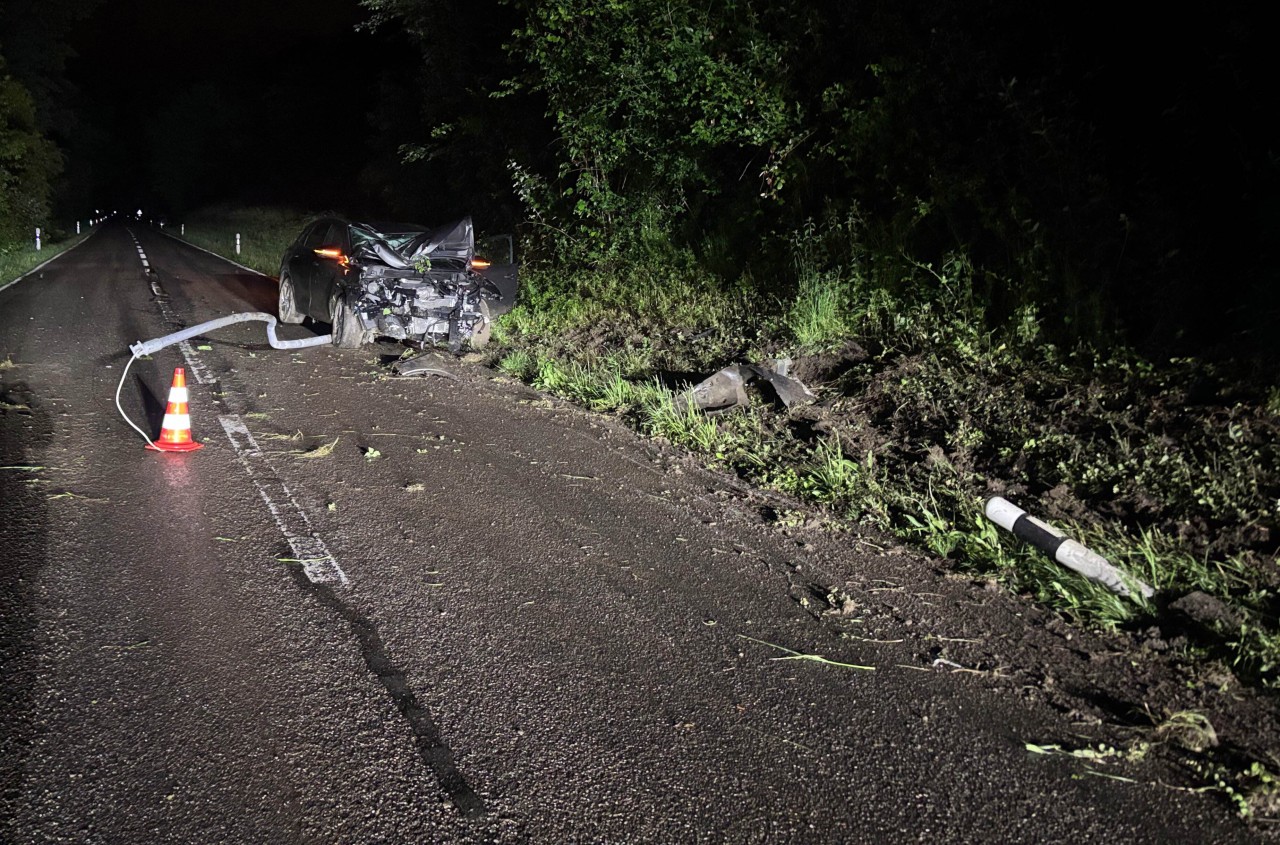 Demolierter Unfallwagen mit verkeilter Strassenlampe.
