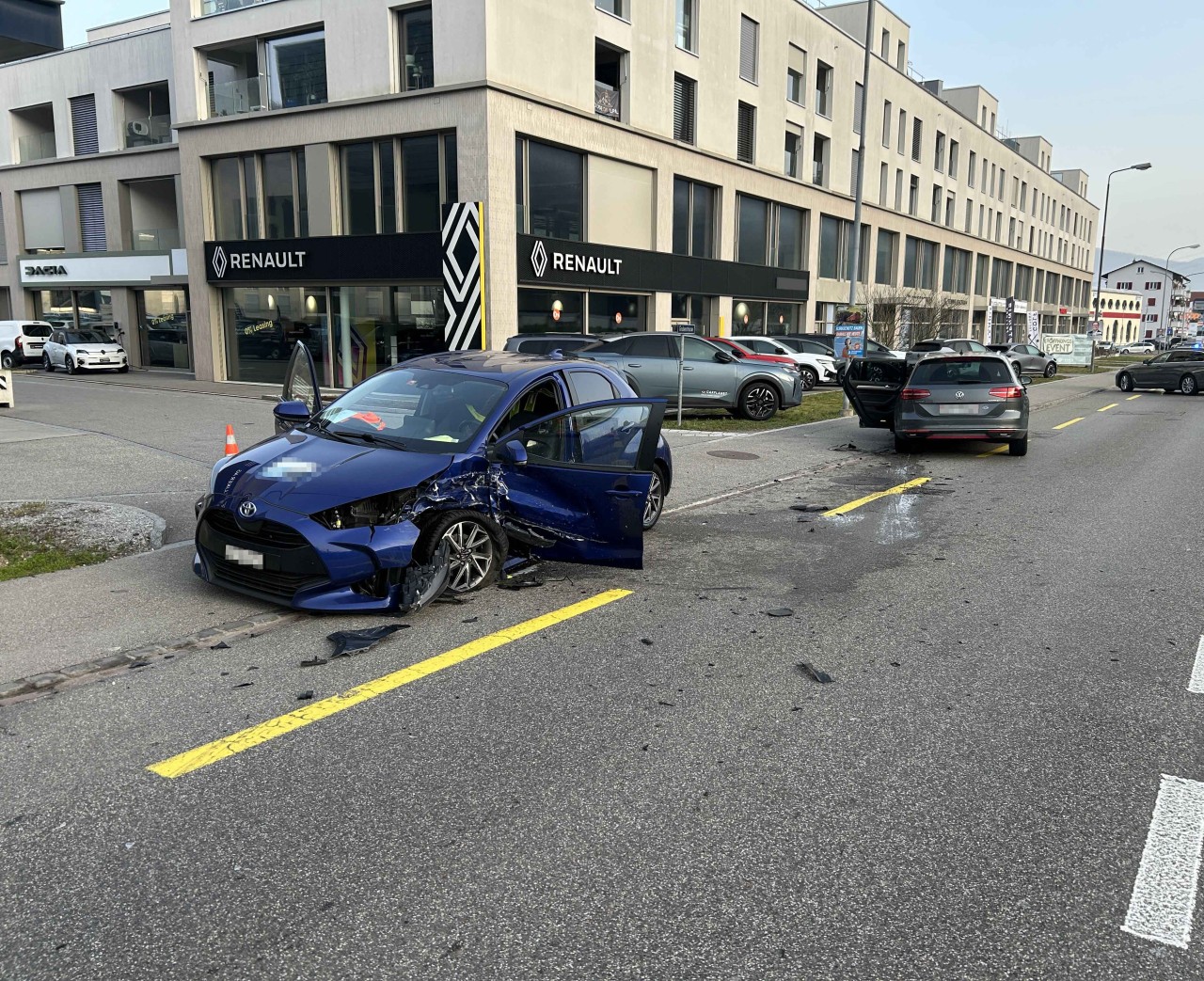Zwei beschädigte Fahrzeuge auf der Fahrbahn bzw. Trottoir. Blauer Toyota und grauer VW.