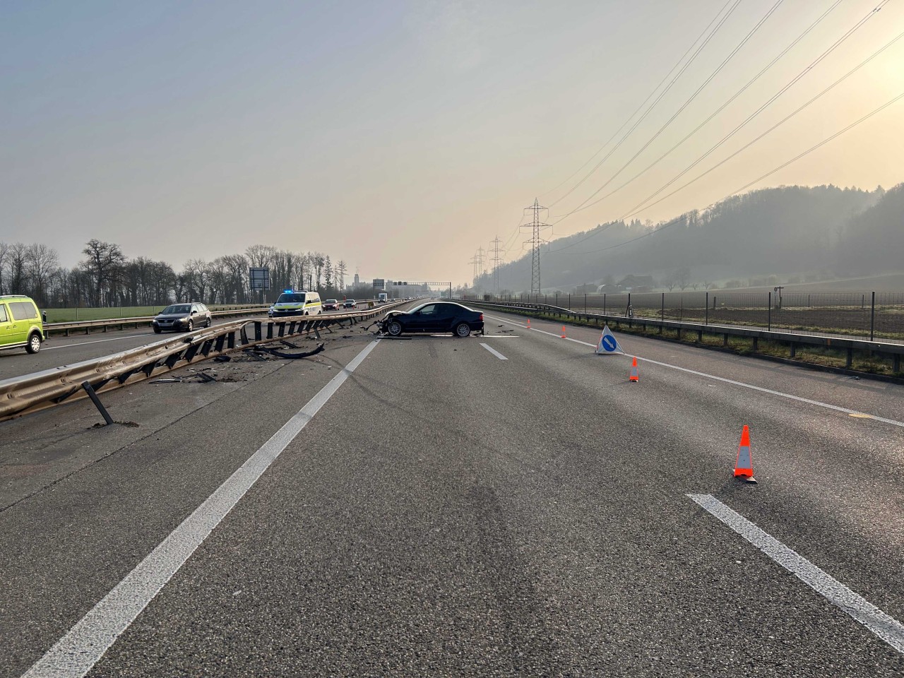 Stark beschädigter BMW steht quer zur Fahrbahn an der Mittelleitplanke. Die Mittelleitplanke ist stark beschädigt.
