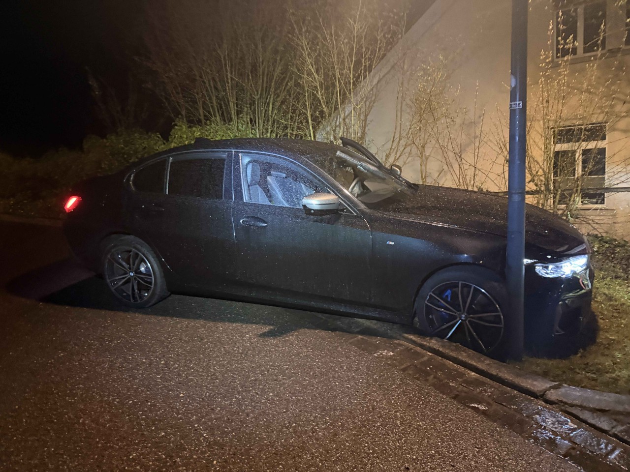 Dunkler BMW, welcher mit einem Kandelaber kollidiert ist. Vorne rechts beschädigt.
