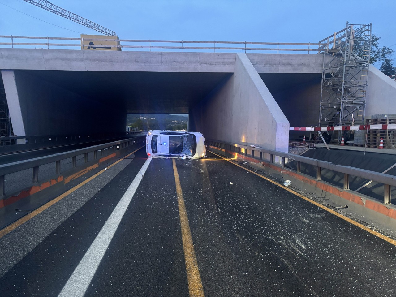 Verunfalltes Fahrzeug, welches seitlich auf der Autobahn liegt.