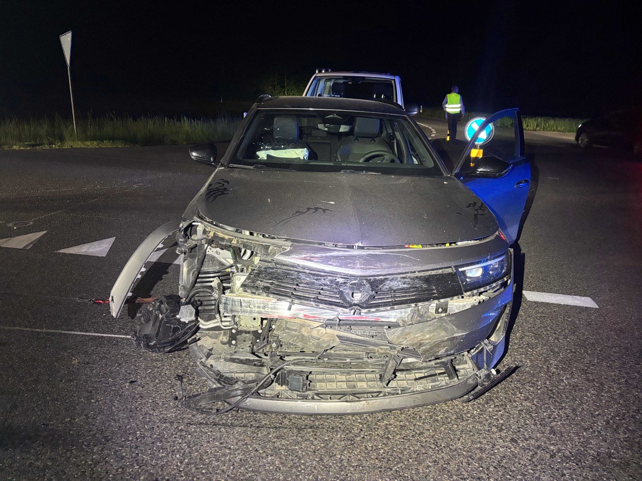 Dunkler Opel Kombi mit einem starken Frontschaden steht auf der Strasse.