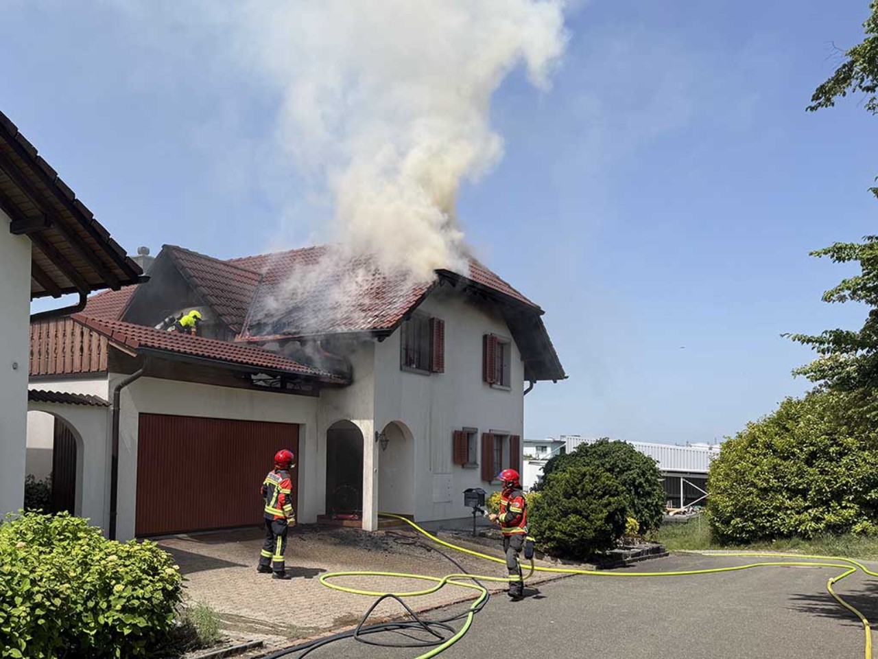 Rauch und Qualm steigt aus Einfamilienhaus empor.
