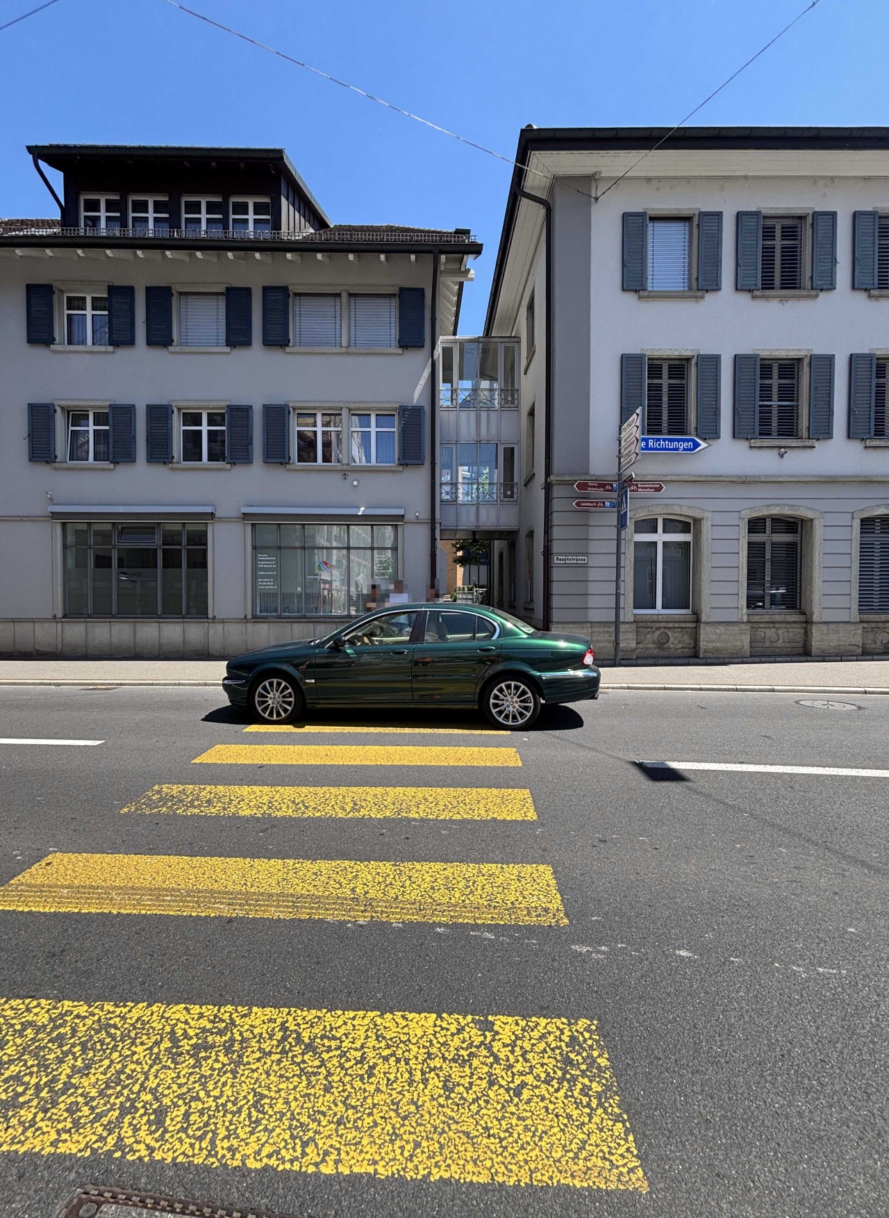 Grünes Auto, welcher auf dem Fussgängerstreifen steht.