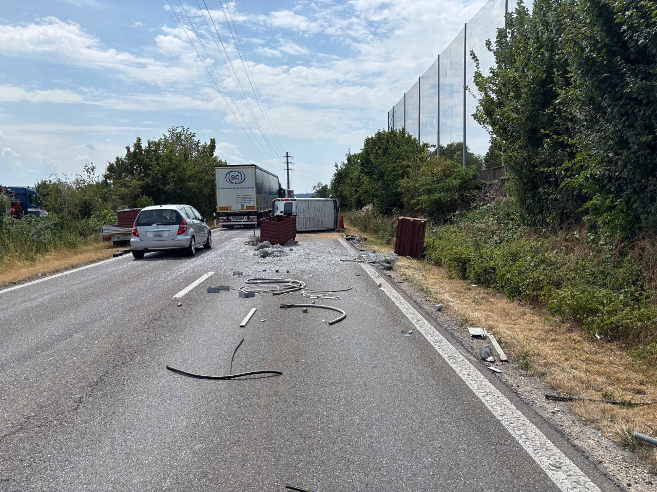 Umgekippter Lieferwagen auf Strasse. Altmetall und Metallspäne auf Strasse verteilt.