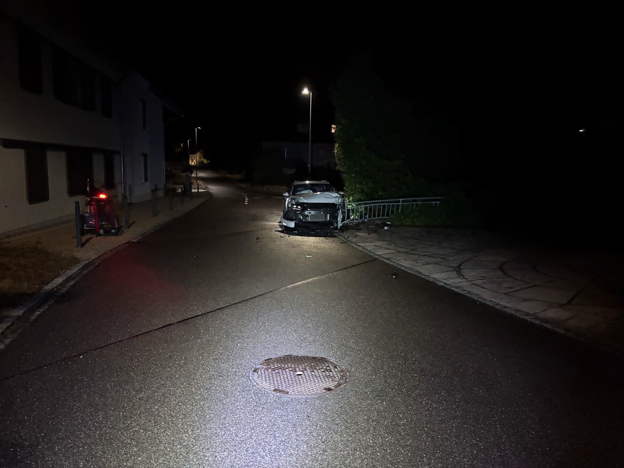 Weisses Auto, welches mit Brückengeländer frontal kollidiert ist. Starke Beschädigung an Front.
