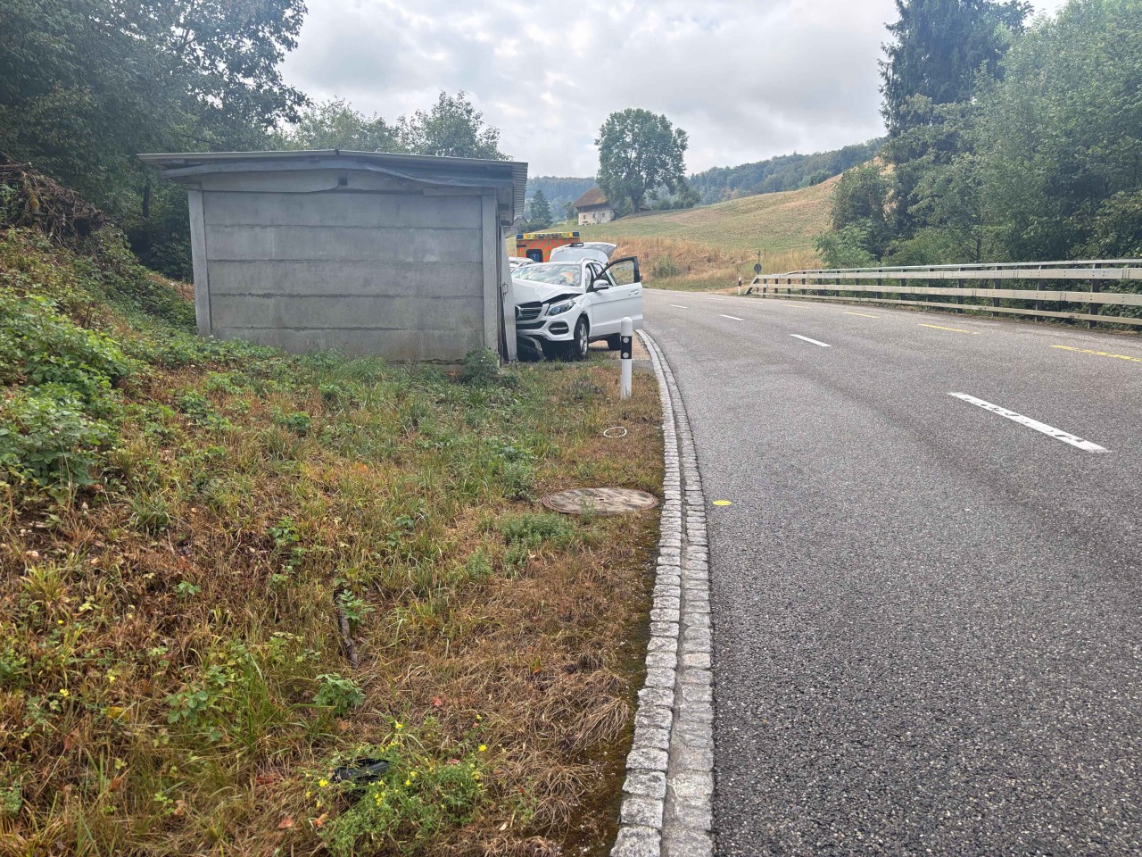Weisser Mercedes ist mit Betongarage kollidiert. Front stark beschädigt.