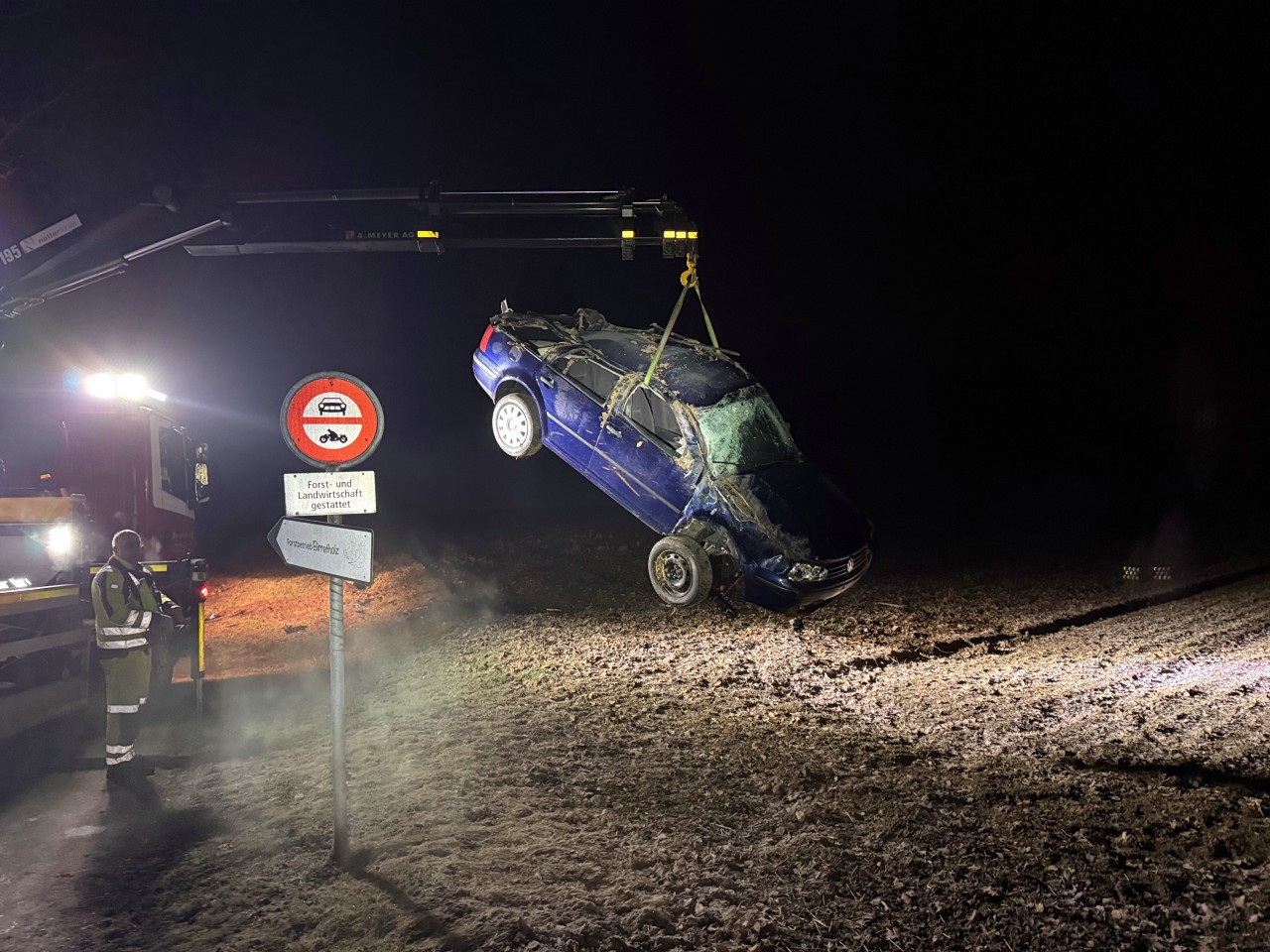 Demolierter Unfallwagen am Kran des Abschleppdienstes.