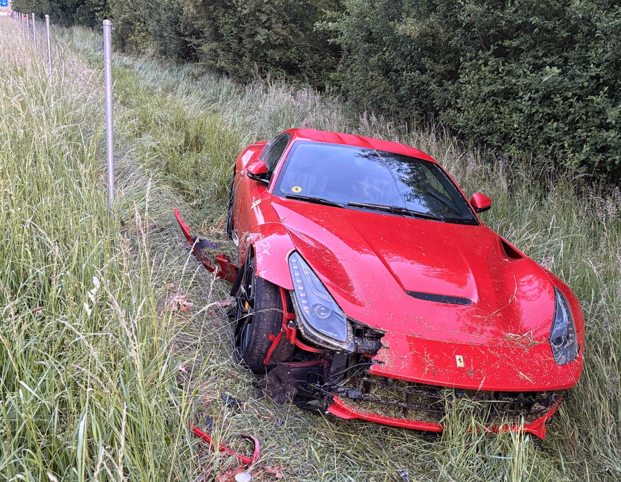 Beschädigter Ferrari im Strassengraben.