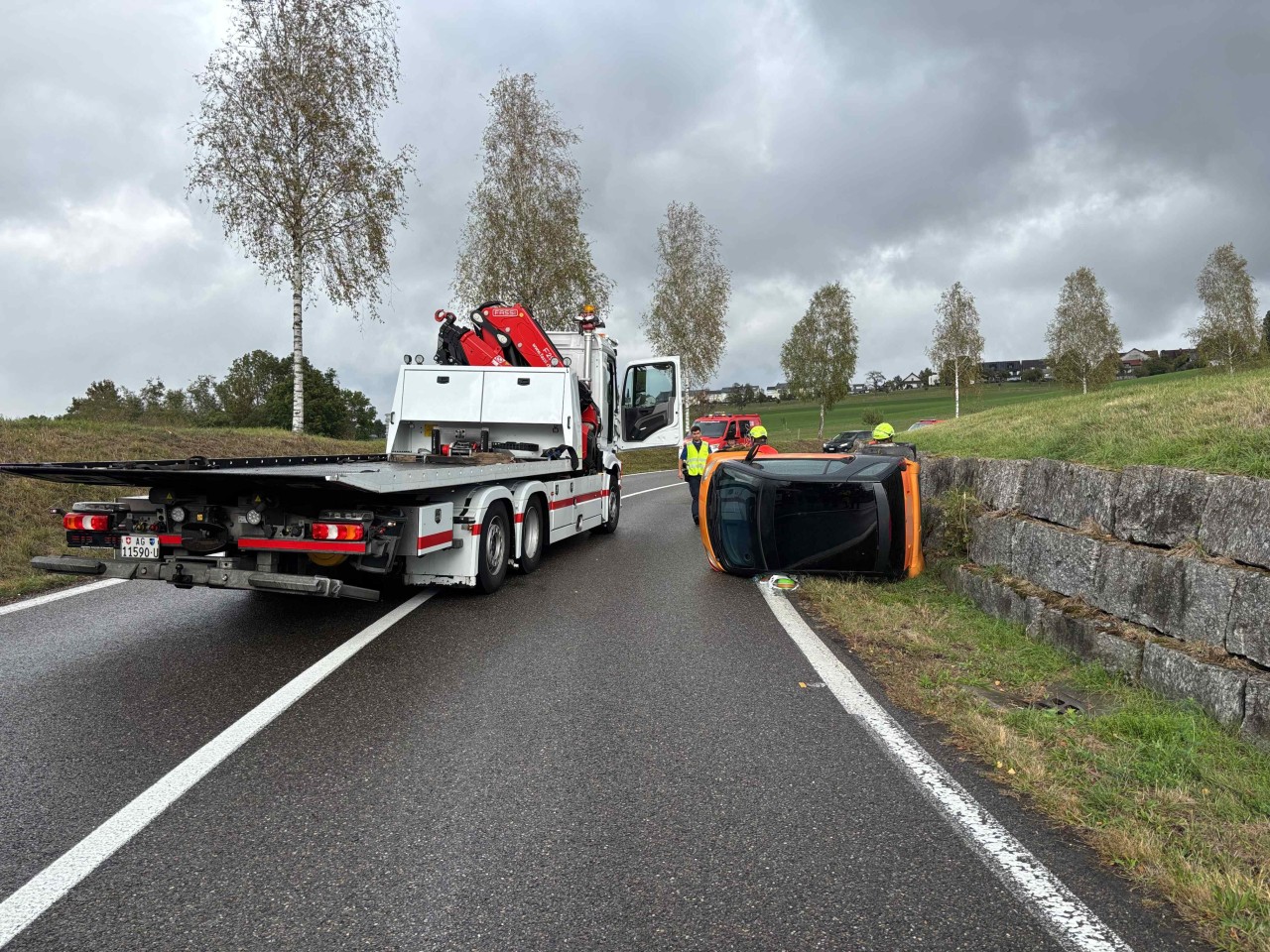 Gekippter Smart liegt neben der Fahrbahn.