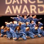 Tanzgruppe in blauen Traineranzügen verweilt in einer Pose