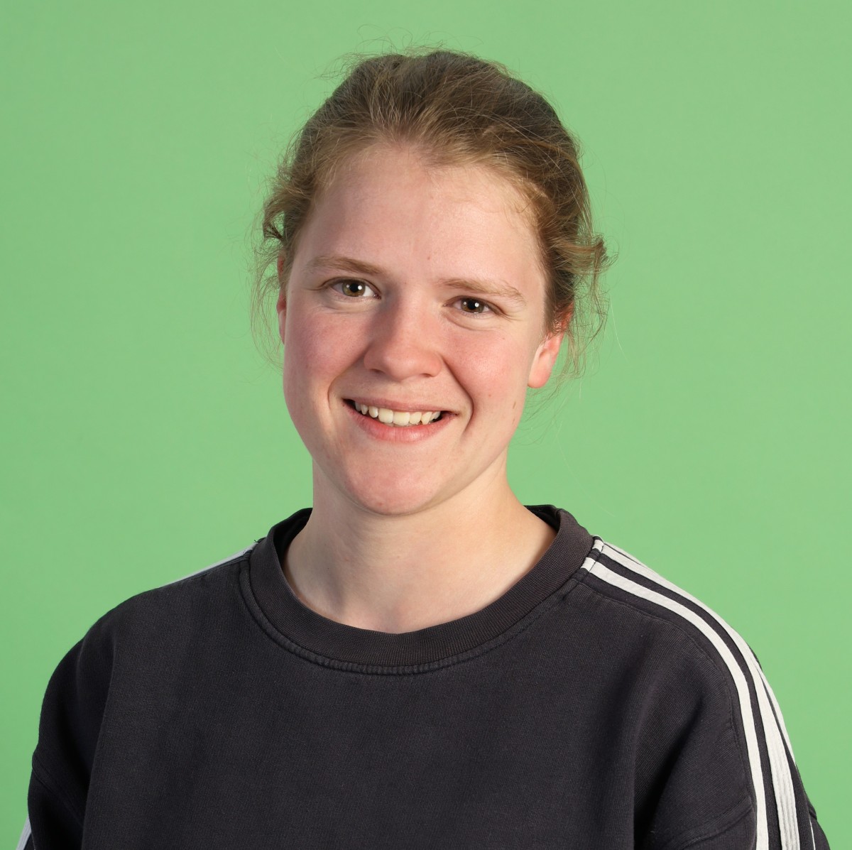 Foto einer Frau auf grünem Hintergrund, lächelt in die Kamera.