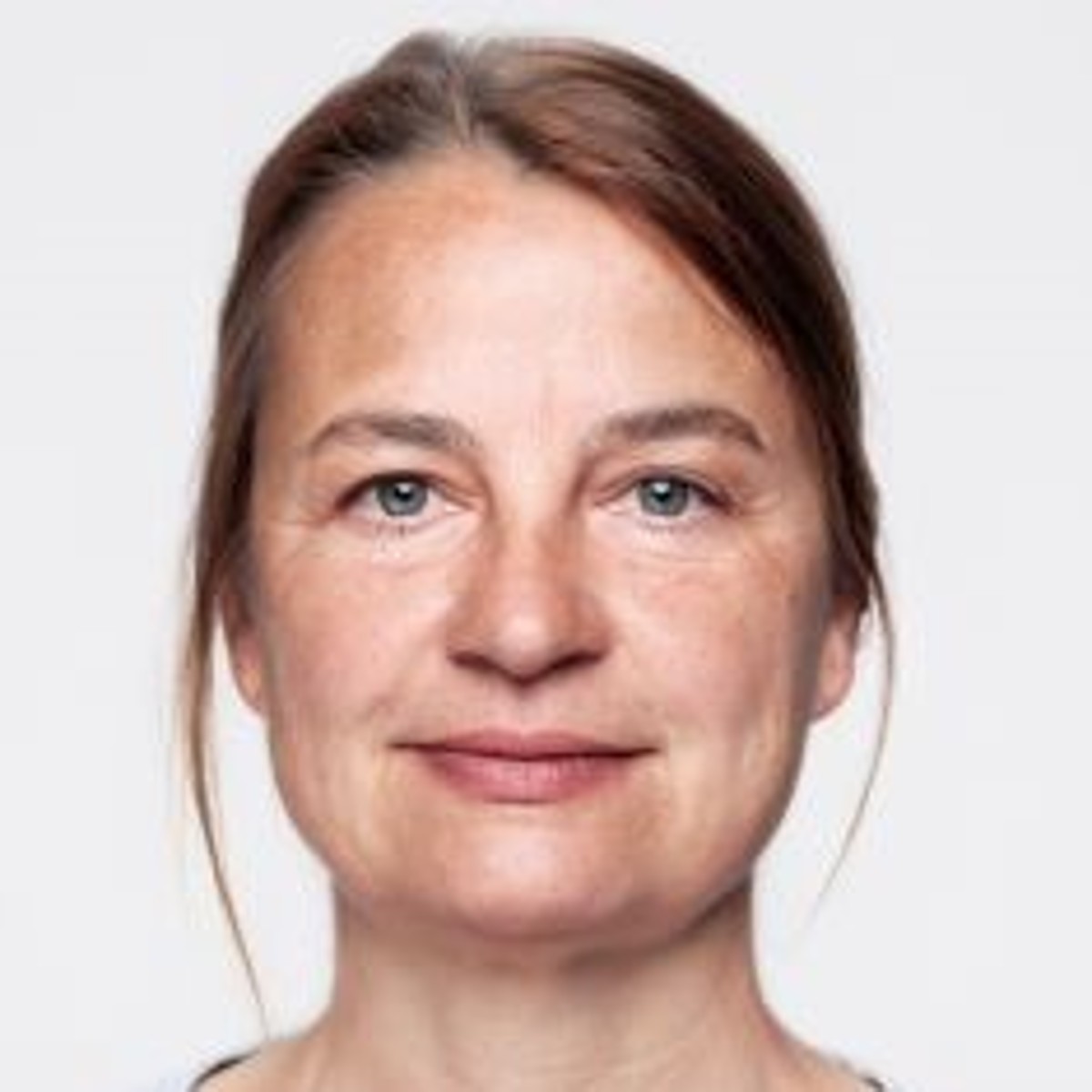 Foto einer Frau auf weissem Hintergrund, lächelt in die Kamera.