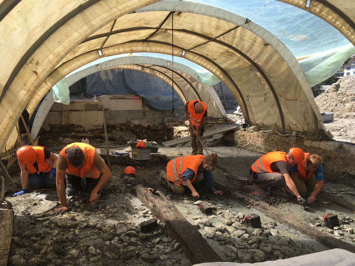 Die Mitarbeitenden der Kantonsarchäologie beim Freilegen der Holzkonstruktion unter dem römischen Bassin.