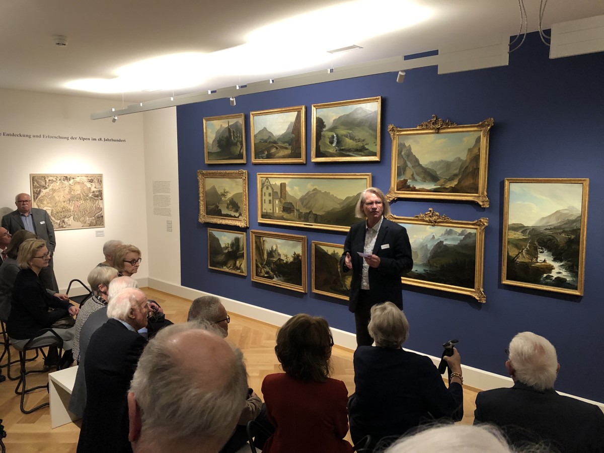 Im Museum Caspar Wolf betrachten Besuchende die Bilder, die auf einer farbigen Wand aufgehängt sind. 