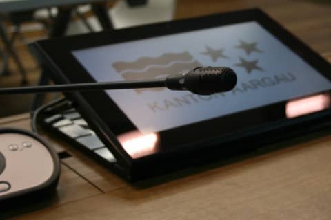 Symbolbild Monitor mit Kantonslogo und Mikrofon