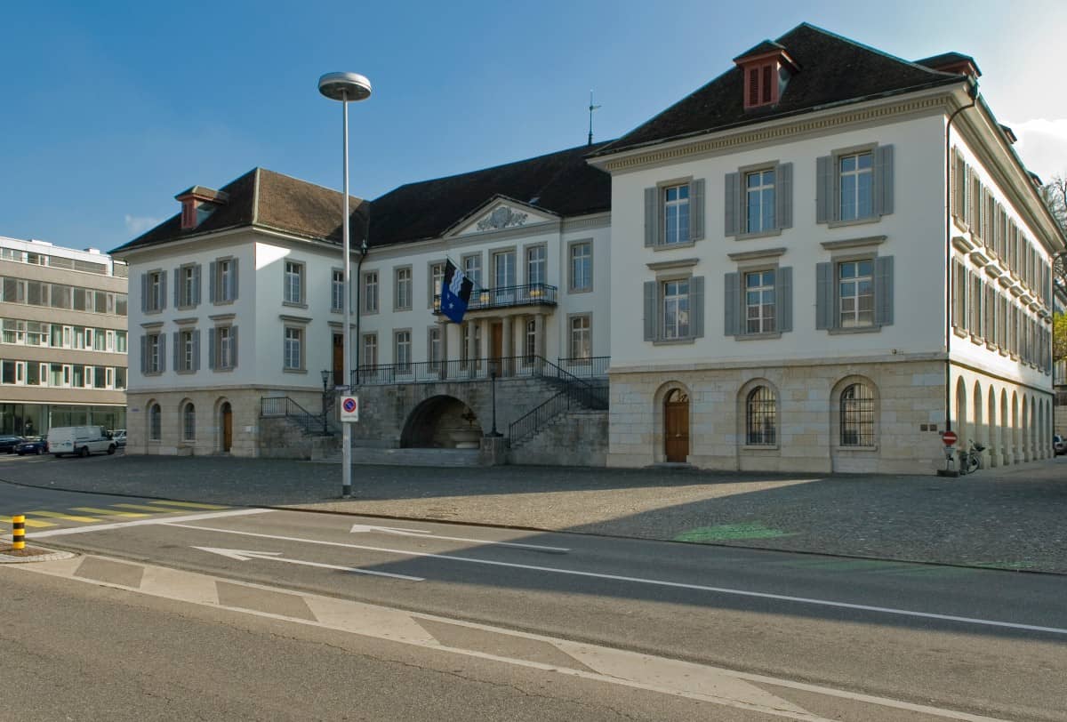 Die ganze Vorderseite des Regierungsgebäudes ist abgebildet, seitlich Links befindet sich der Aargauerplatz