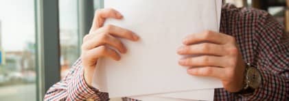 Eine Person hält Papier in den Händen