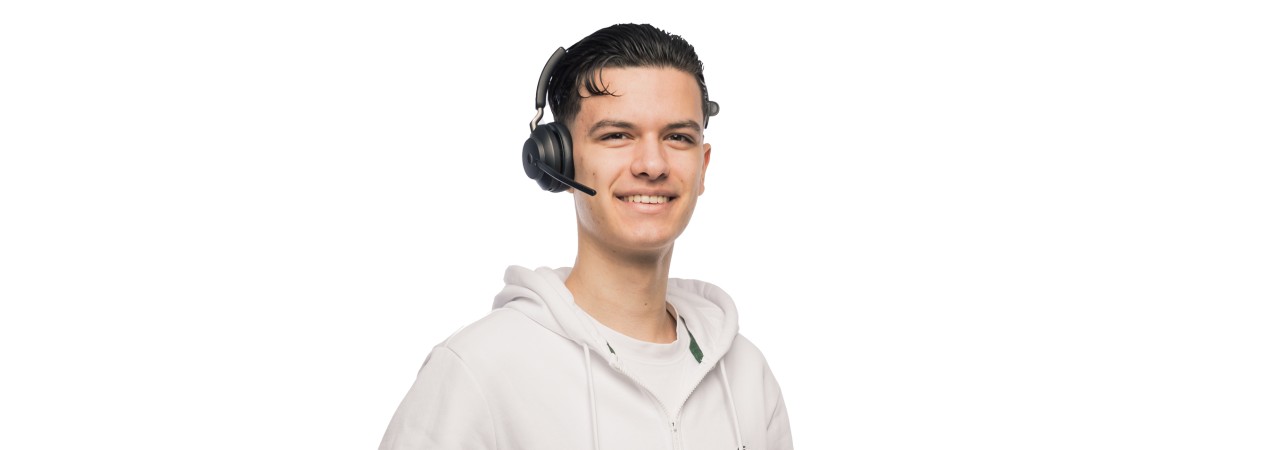 Eine junge, männliche Person mit Laptop in der Hand 