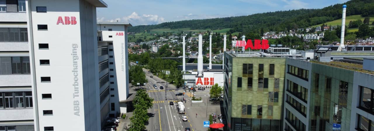 Blick auf verschiedene Gebäude entlang einer Strasse mit der Anschrift ABB in Rot 