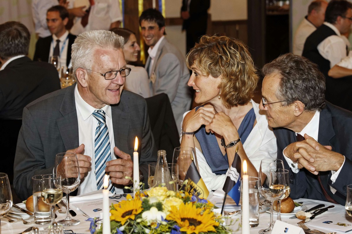 Der Ministerpräsident Winfried Kretschmann, Frau Landamman Susanne Hochuli und Botschafter Dr. Tim Guldimann sitzen am Esstisch im Schloss Lenzburg sind in eine Diskussion vertieft