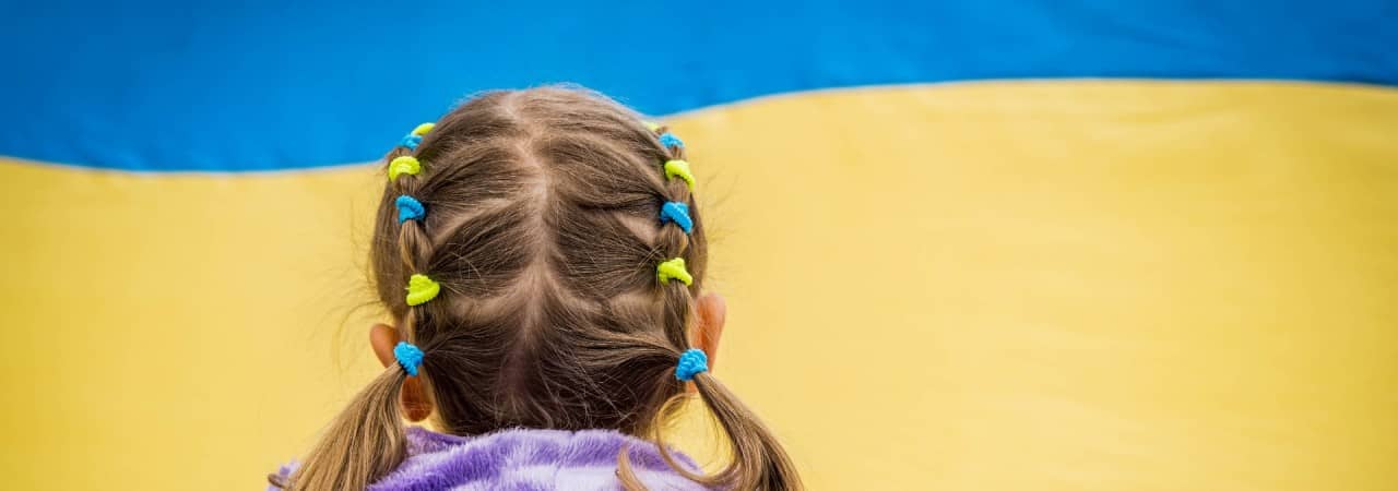 Mädchen schaut ukrainische Flagge an