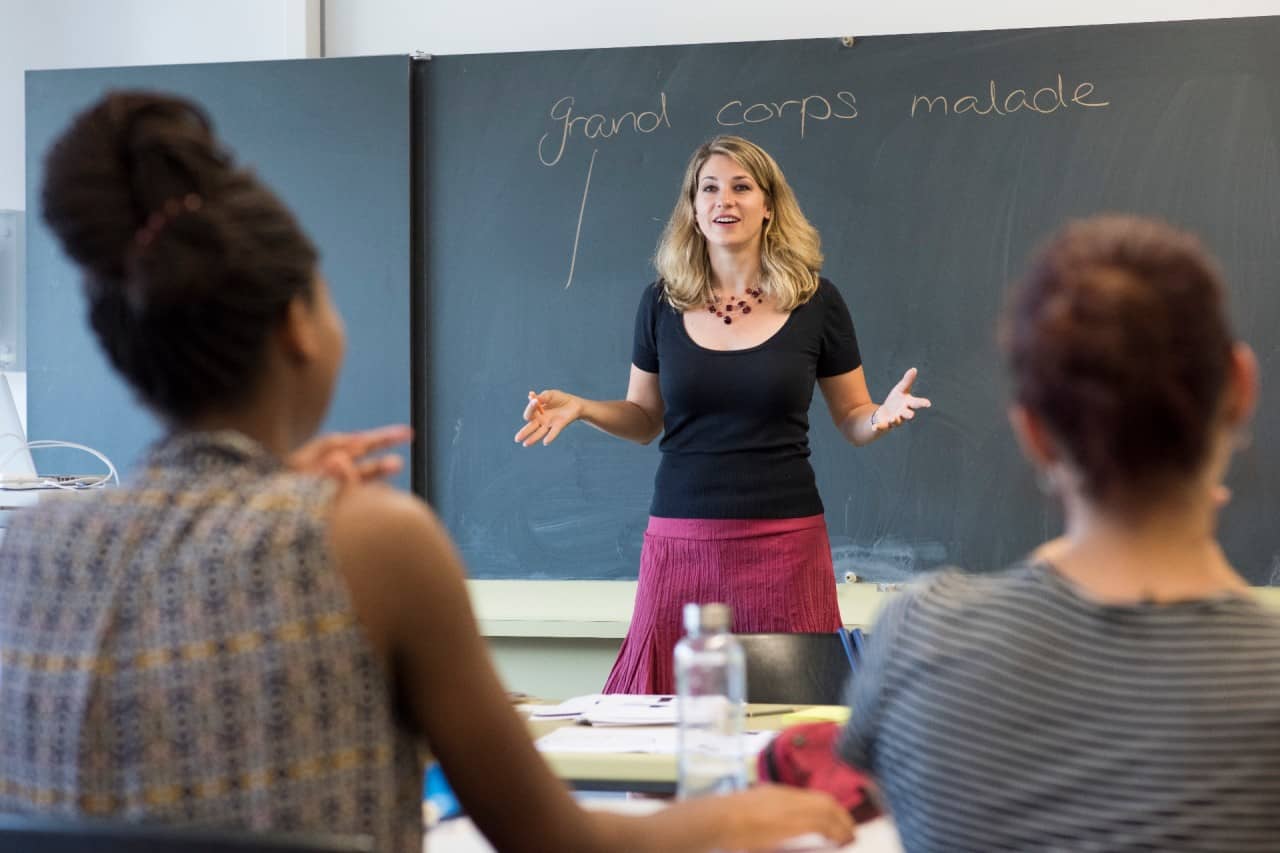 Gymnasialleehrerin im Frontalunterricht vor einer Schulklasse