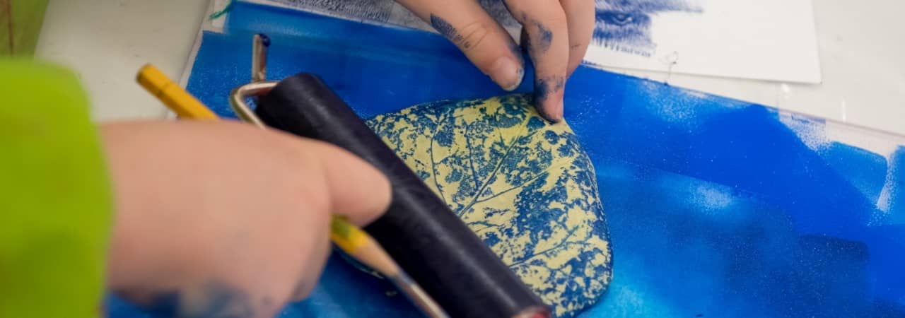 Eine Schülerin oder ein Schüler benutzt einen Rollstempel. 