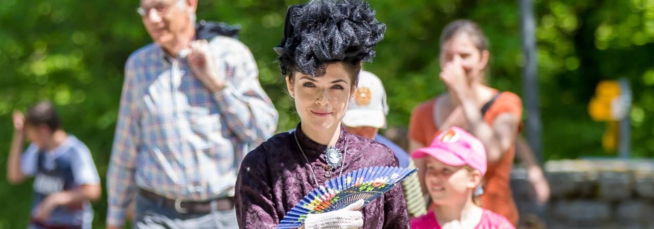Eine verkleidete Museumsführerin mit Besucherinnen und Besuchern