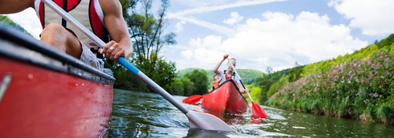 Eine Kanugruppe ist auf dem Fluss unterwegs.