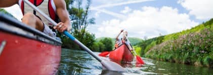 Eine Kanugruppe ist auf dem Fluss unterwegs.