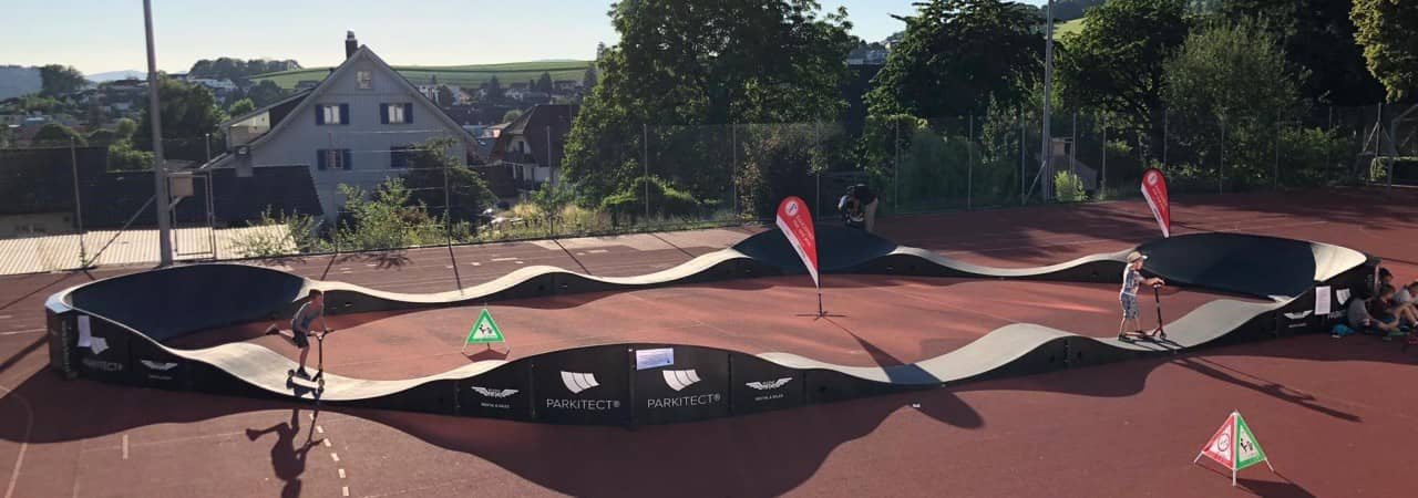Kinder und Jugendliche fahren auf einem mobilen Pumptrack.