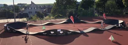 Kinder und Jugendliche fahren auf einem mobilen Pumptrack.